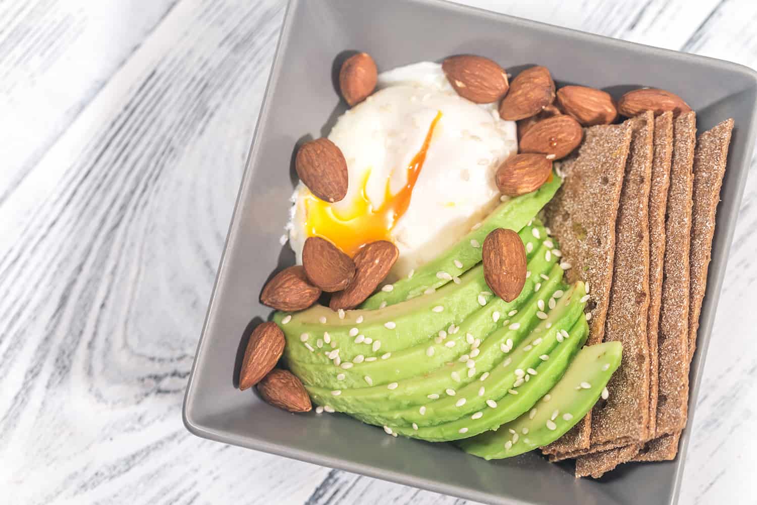 Poached egg with avocado and almonds